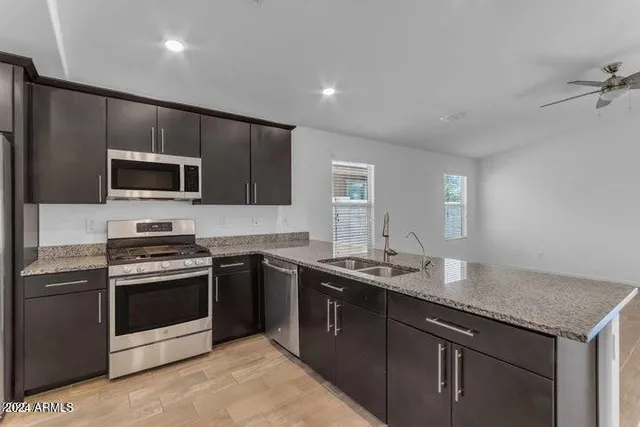 a kitchen with stainless steel appliances granite countertop a refrigerator and a stove top oven