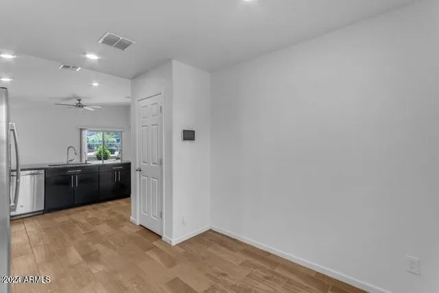a view of a hallway with wooden floor and a living room