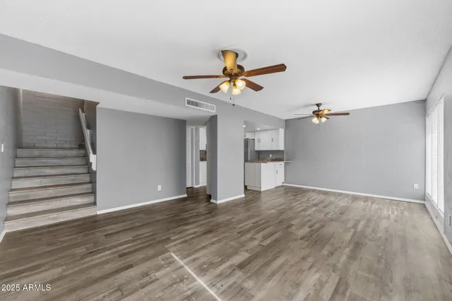 a view of a room with wooden floor and ceiling fan
