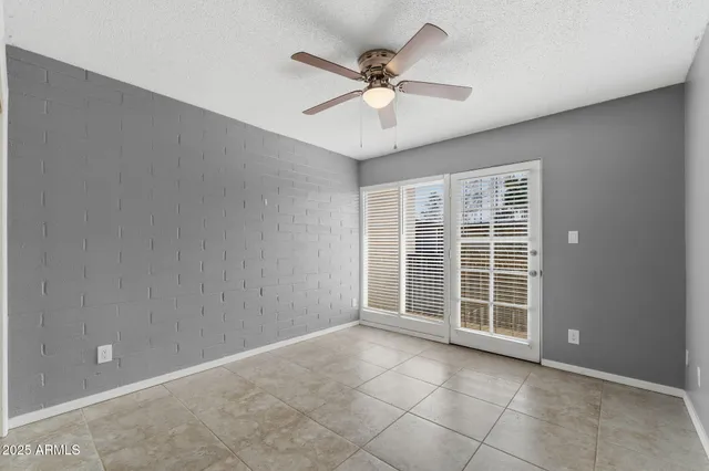 an empty room with window and a ceiling fan
