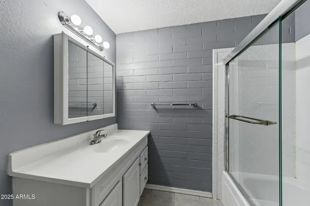 a bathroom with a sink mirror and shower
