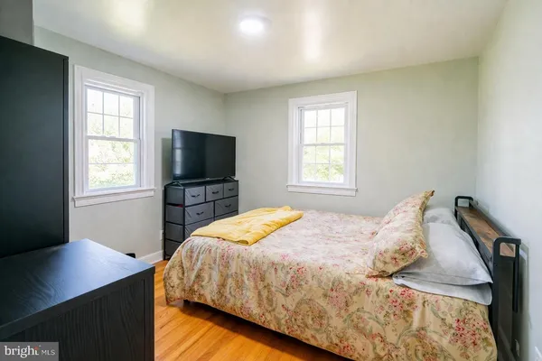 a bedroom with a bed and a flat tv screen on a dresser