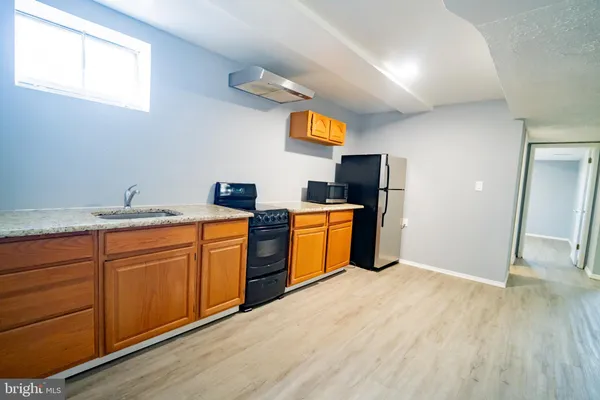 a kitchen with stainless steel appliances granite countertop a sink and a wooden floor