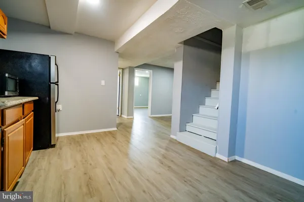 a view of a hallway with wooden floor and staircase