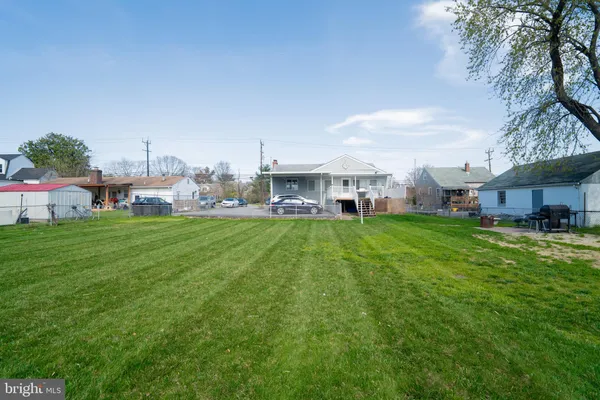 a view of a house with a big yard and sitting area