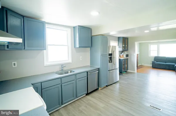 a kitchen with a sink cabinets and wooden floor