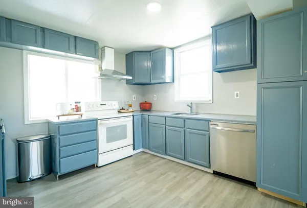 a kitchen with a white stove top oven sink and window