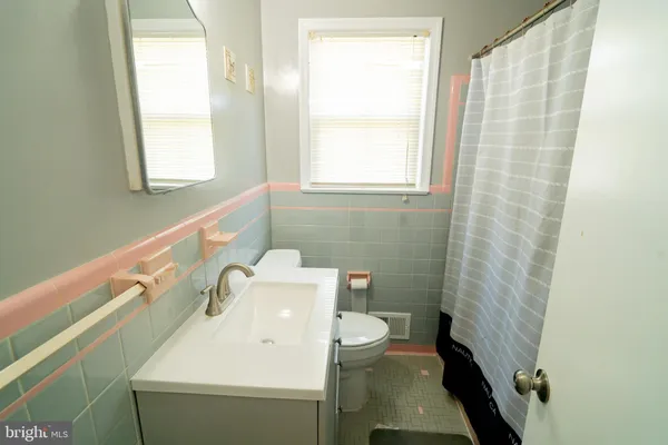 a bathroom with a sink a toilet and a window