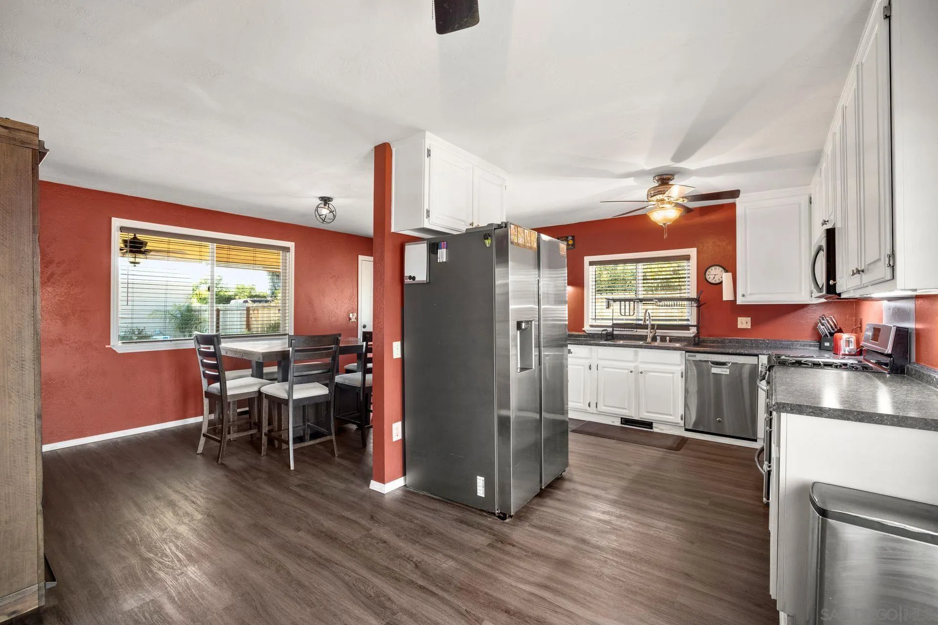 28436 Sunset Road Valley Center, CA 92082 - Photo 10 of 36 a kitchen with stainless steel appliances granite countertop a refrigerator a stove top oven a dining table and chairs with wooden floor