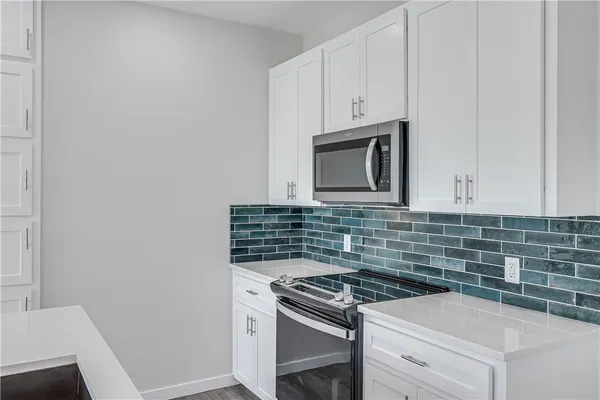 a kitchen with kitchen island granite countertop stainless steel appliances a sink stove and cabinets
