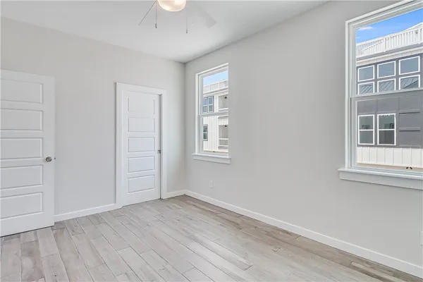 an empty room with wooden floor and windows