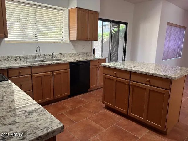 a kitchen with granite countertop a sink and a stove