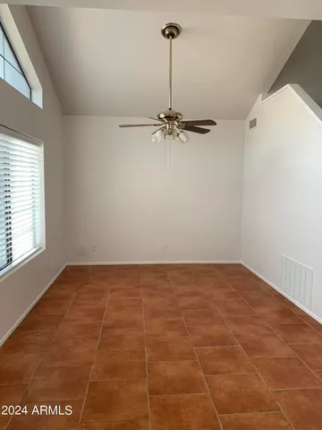 a view of a room with a ceiling fan and window
