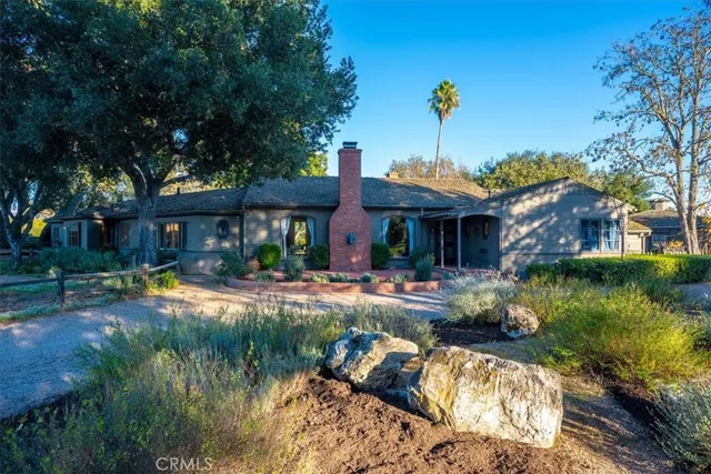 a dining room with wooden floor a chandelier a glass table and chairs