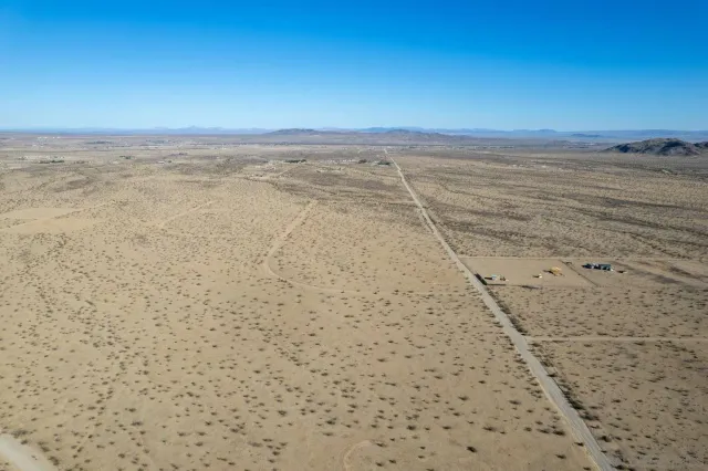 a view of a dry yard with mountains in the background