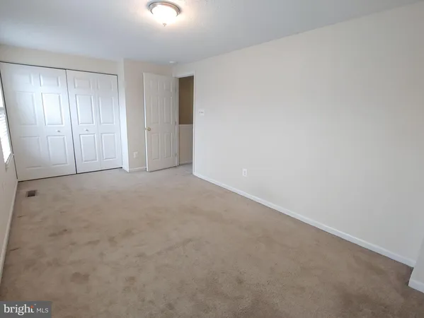 a view of an empty room and closet area