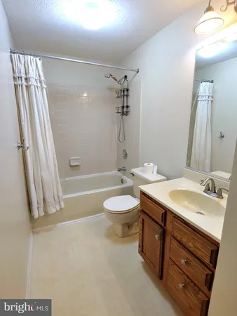 a bathroom with a granite countertop sink toilet a mirror and shower