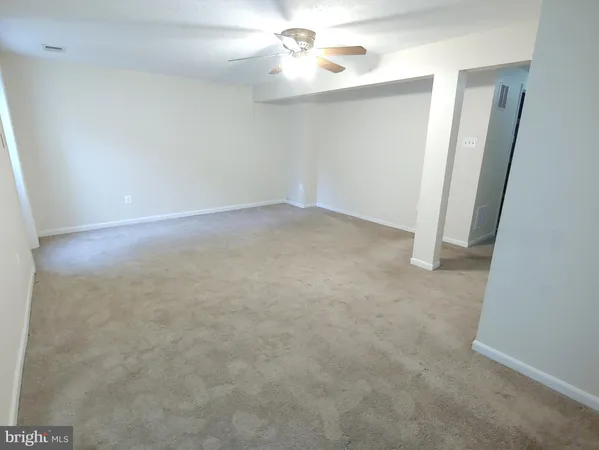 an empty room with closet and a chandelier fan