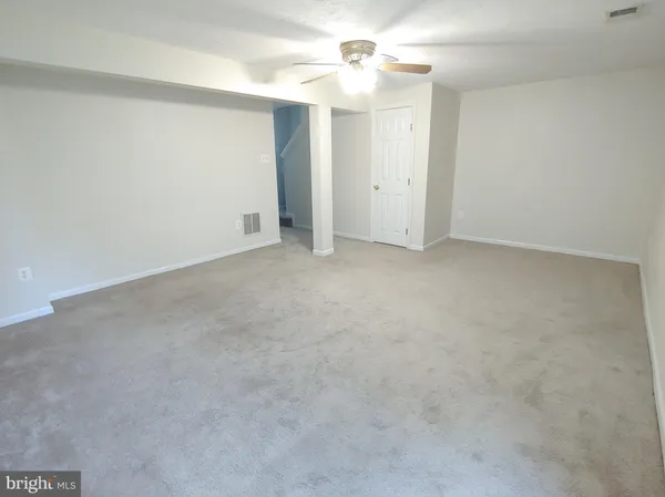 an empty room with a ceiling fan and a window