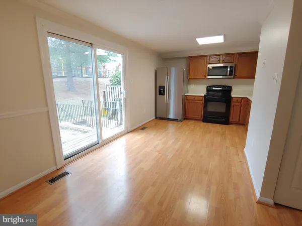 a kitchen with stainless steel appliances a refrigerator a sink a stove top oven with wooden floor