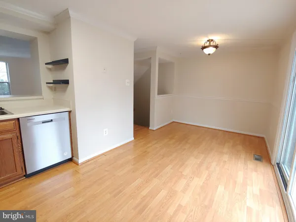a view of a room with wooden floor and white walls