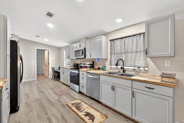 a kitchen with a sink cabinets stainless steel appliances and a window