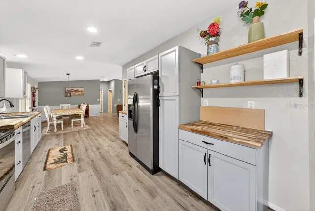 a kitchen with white cabinets and stainless steel appliances