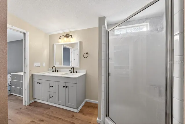 a bathroom with a double vanity sink mirror and shower