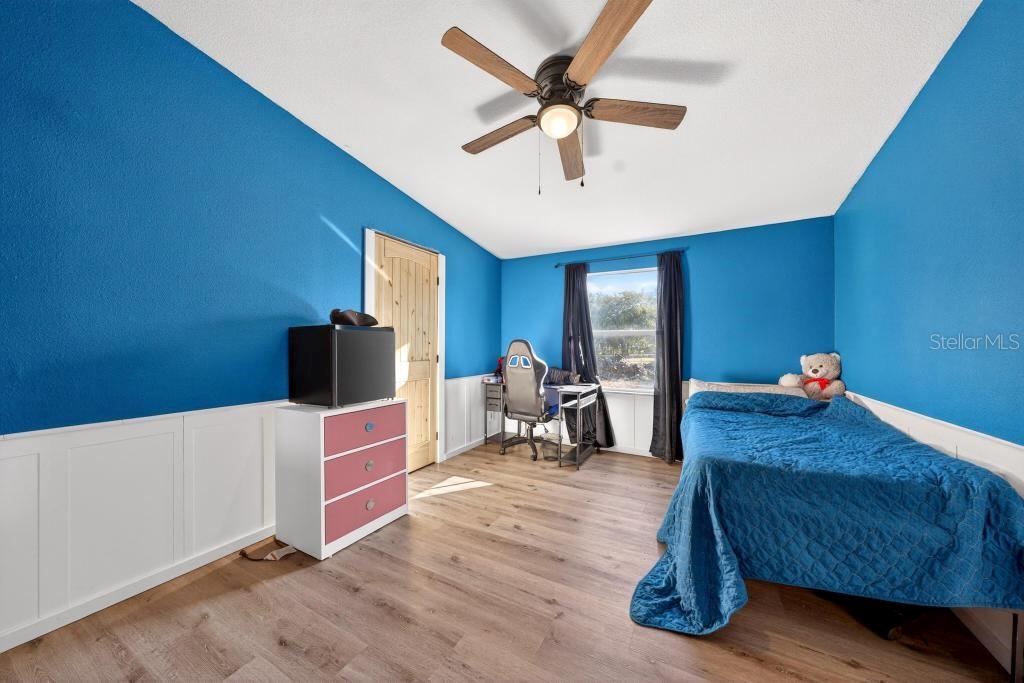 40100 Jim Scotts Road Leesburg, FL 34788 - Photo 27 of 40 a bed room with a bed and a chandelier