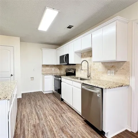 a kitchen with a sink stove and cabinets