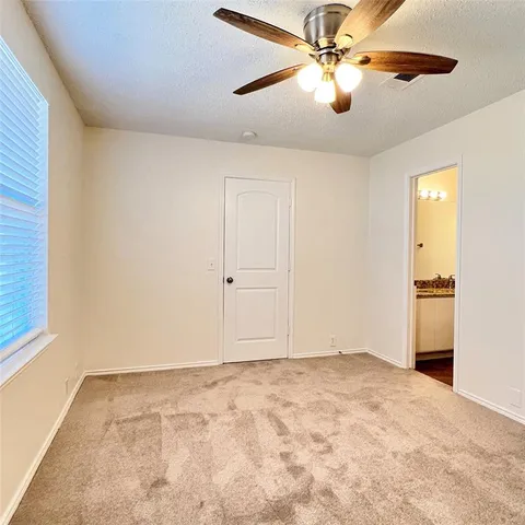 a view of a room with a ceiling fan and a window