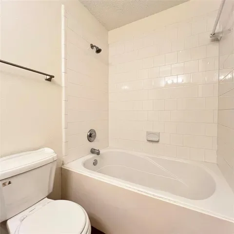 a white toilet sitting next to a bath tub