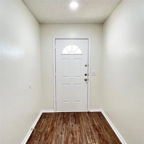 an empty room with wooden floor and mirror