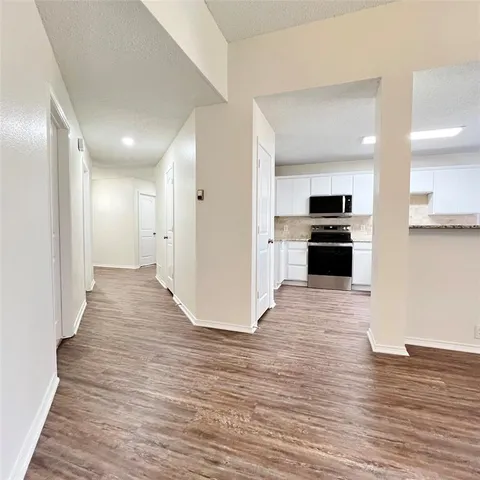 a view of kitchen with refrigerator stove and wooden cabinets