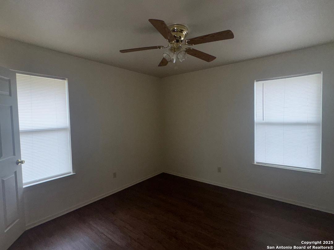 827 Dallas Street Pleasanton, TX 78064 - Photo 8 of 8 an empty room with wooden floor closet and windows