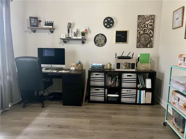 a view of a workspace with furniture and wooden floor