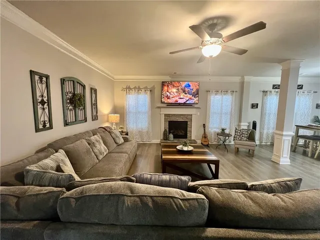 a living room with furniture a flat screen tv and a fireplace