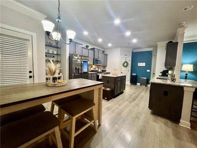 a large kitchen with lots of counter space a sink appliances and cabinets