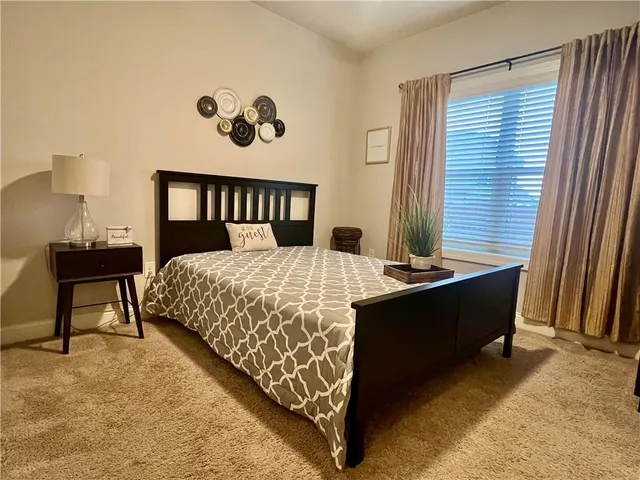 a bed sitting in a bedroom next to a window