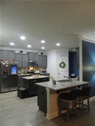 a kitchen with kitchen island stainless steel appliances a sink stove and cabinets