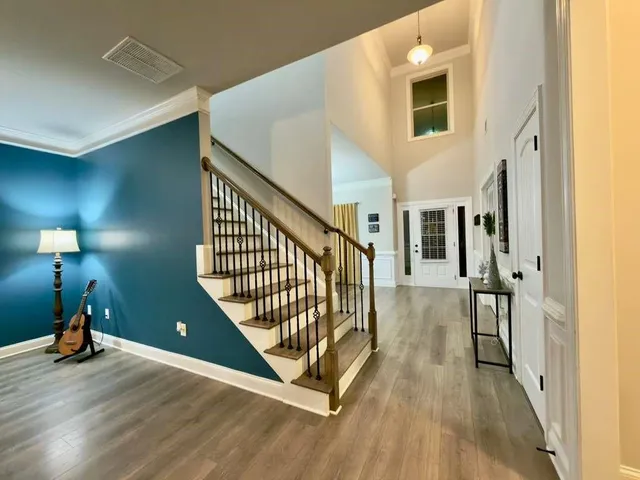 a view of a hallway with wooden floor and stairs