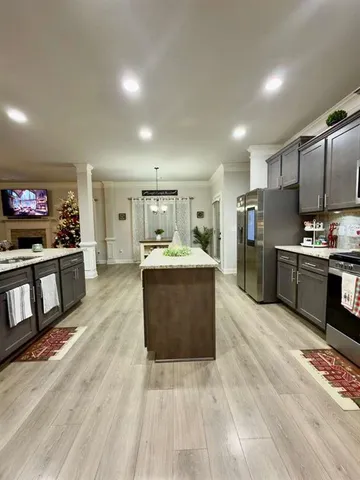 a large kitchen with stainless steel appliances kitchen island a large counter top and a wooden floors