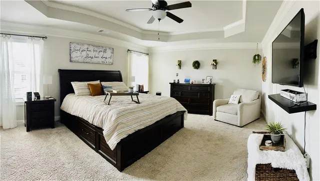 a spacious bedroom with a bed and a flat screen tv