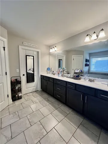 a large bathroom with a sink mirror and shower