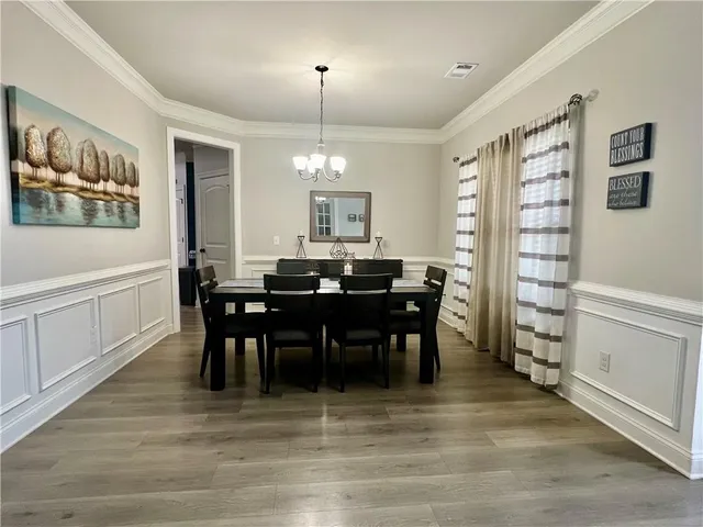a view of a a dining room with furniture window and wooden floor