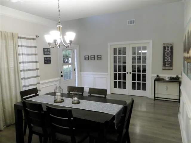 a view of a dining room with furniture wooden floor and chandelier