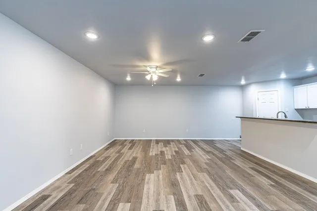 a view of empty room with wooden floor