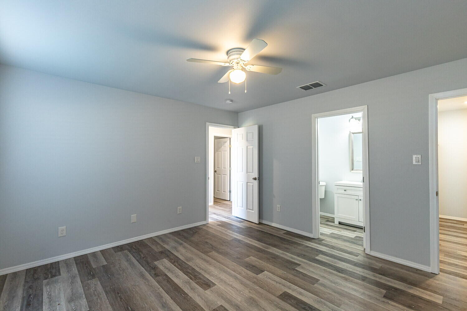1104 North Englewood Avenue, Unit B Lubbock, TX 79416 - Photo 10 of 11 an empty room with wooden floor fan and windows