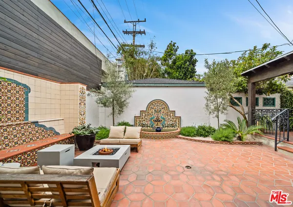 a roof deck with table and chairs and potted plants