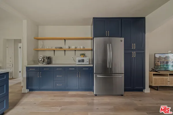 a large kitchen with cabinets wooden floor and stainless steel appliances